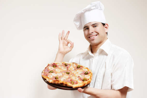 Happy attractive cook with a pizza - Zdjęcie, obraz