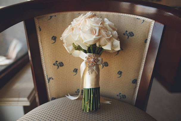 Bouquet da sposa con rose rosa su una sedia
 - Foto, immagini