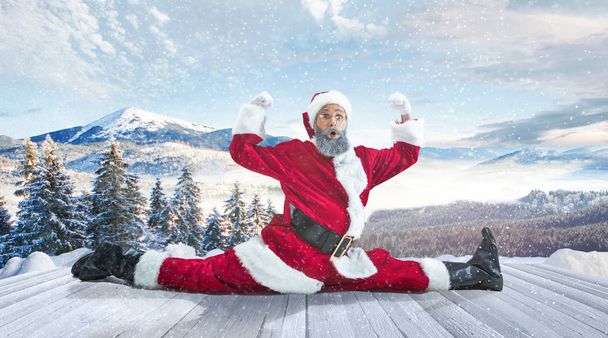 Santa Claus with traditional red white costume in front of white snow winter landscape panorama - Photo, image