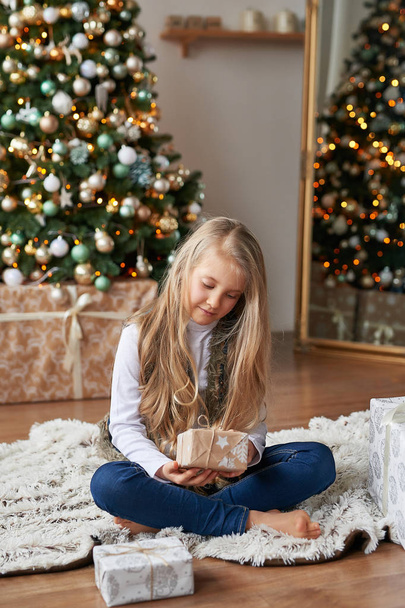 blonde girl with gifts in the New Year's interior - Photo, Image
