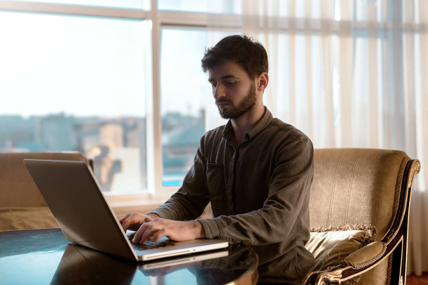 ernsthaft und junge Hipster-Typ mit Laptop-Computer, Person Arbeit zu Hause - Foto, Bild