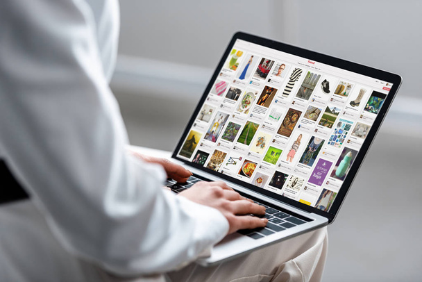 abgeschnittene Ansicht einer Frau mit Laptop und Pinterest-Website auf dem Bildschirm - Foto, Bild