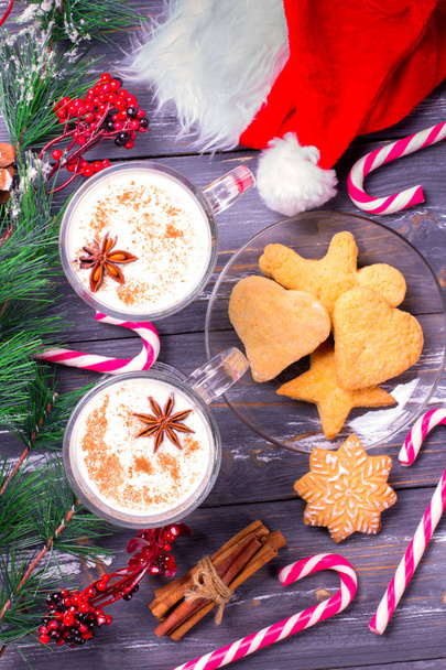 Christmas eggnog in glass mug and cinnamon. Christmas decorations - Фото, зображення