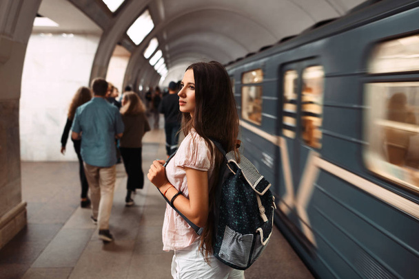 Metro ile geri harekete hazır çantalı kız - Fotoğraf, Görsel