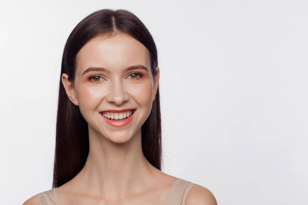 Portrait of a smiling beautiful young woman. White background - Φωτογραφία, εικόνα