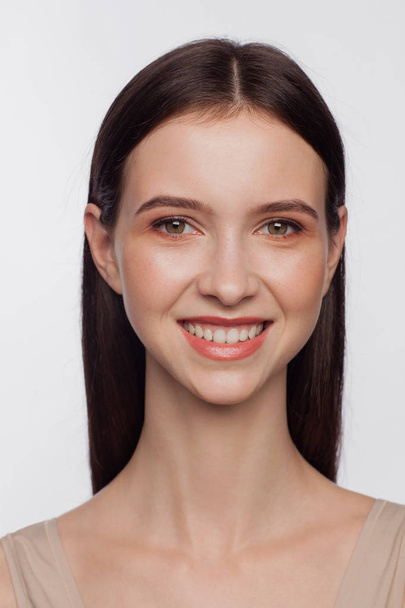 Portrait of a smiling beautiful young woman. White background - Zdjęcie, obraz