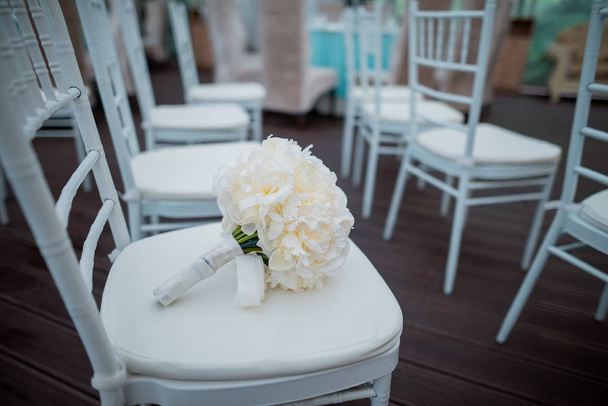 Νυφική ανθοδέσμη σε λευκή καρέκλα, Γάμος διακόσμηση - Φωτογραφία, εικόνα