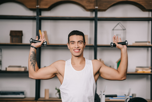 hombre bi-racial tatuado haciendo ejercicio con pesas
  - Foto, imagen