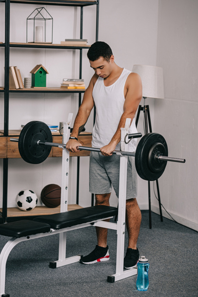 handsome  bi-racial man workout with barbell in home gym  - Zdjęcie, obraz