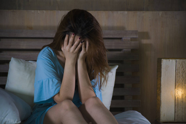 young desperate and depressed woman crying in bed at night having  depression problem and anxiety crisis feeling sad as girl suffering broken heart or cyber bullying in dramatic light - Foto, imagen