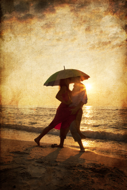 Pár csók a strandon napernyő alatt, a naplemente. O Fotó - Fotó, kép
