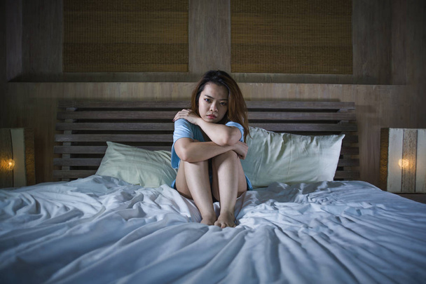 young beautiful and depressed Asian Chinese woman crying in bed at night having  depression problem and anxiety crisis feeling sad in girl suffering broken heart or cyber bullying concept - Foto, Imagem