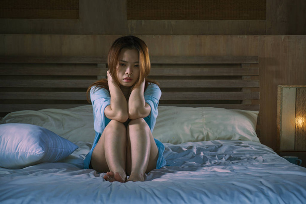 young beautiful and depressed Asian Chinese woman crying in bed at night having  depression problem and anxiety crisis feeling sad in girl suffering broken heart or cyber bullying concept - Foto, Bild