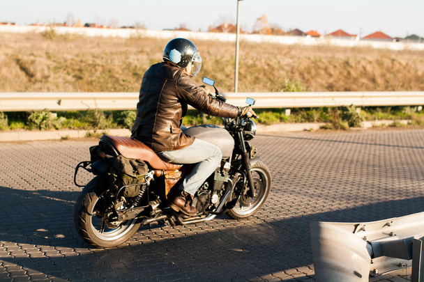 Muž a starý motocykl vlastní café-racer na lesní při západu slunce - Fotografie, Obrázek