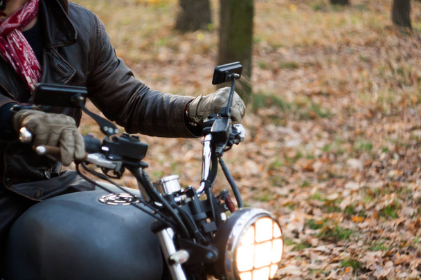 Hombre y viejo café-corredor personalizado Motocicleta en el bosque al atardecer
 - Foto, Imagen