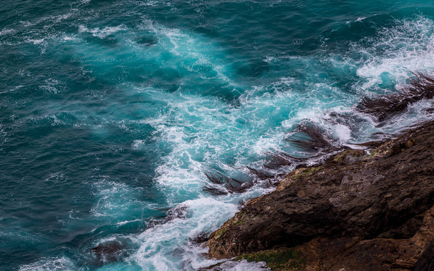 Suuri merimaisema aaltoilevalla vedellä ja rannalla
  - Valokuva, kuva