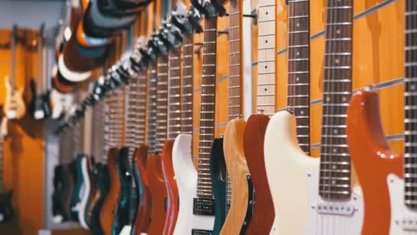 Wiele gitar elektrycznych, wiszące w sklepie muzycznym. Instrumenty muzyczne sklep - Materiał filmowy, wideo