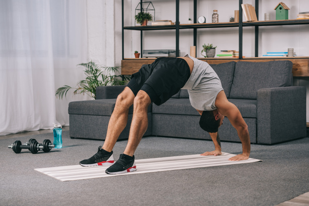 bi-racial man doing bridge exercise in sportswear on fitness mat - Valokuva, kuva