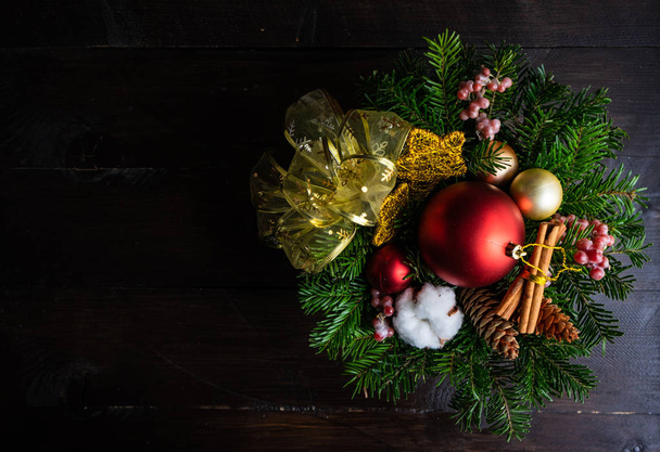 Christmas card concept on rustic dark wooden background with bright balls, fir tree and cotton heads - 写真・画像