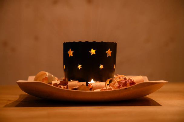 ζεστή διάθεση Χριστούγεννα κερί φως τσαγιού στο ξύλινο πιάτο με ροκανίδια  - Φωτογραφία, εικόνα