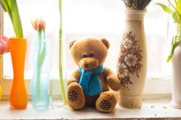 primo piano di orsacchiotto con fiori freschi sul davanzale della finestra
  - Foto, immagini