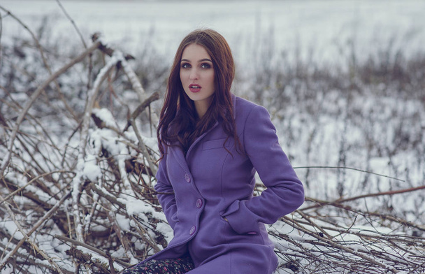 Donna alla moda in cappotto viola in posa fuori nel periodo invernale
 - Foto, immagini