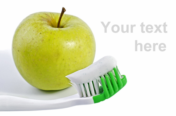 Hammasharja hammastahnalla ja vihreä omena eristetty yli valkoinen
 - Valokuva, kuva