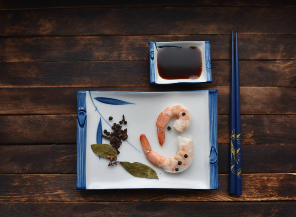 crevettes bouillies fraîches avec des épices sur des assiettes traditionnelles japonaises et des baguettes
 - Photo, image