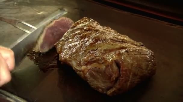 Koch schneidet großes Stück Fleisch. Dabei einen Grill grillen. Schneiden von Fleischstücken auf der Grillplatte. - Filmmaterial, Video