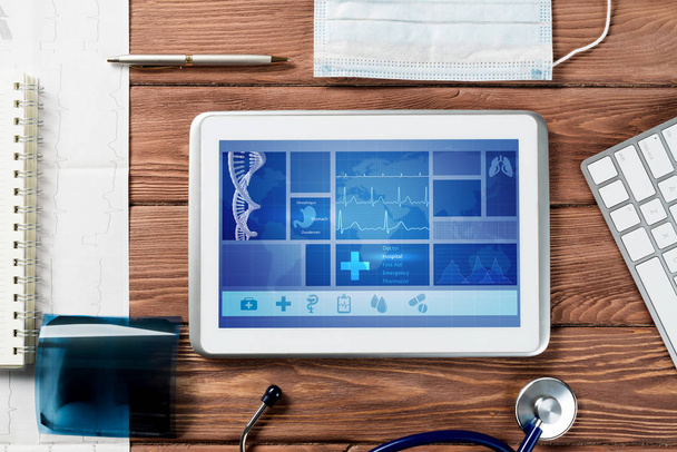 White tablet pc and doctor tools on wooden table - 写真・画像