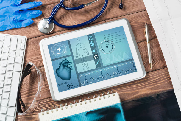 White tablet pc and doctor tools on wooden table - Photo, Image