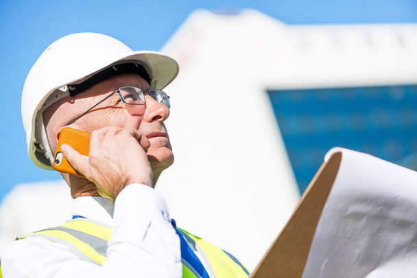 Senior engineer man in suit and helmet talking mobile phone - Foto, Bild