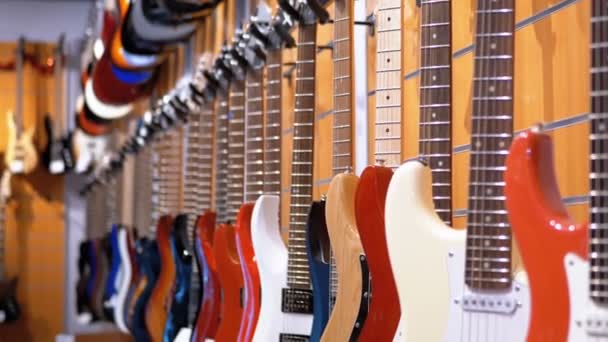 エレク トリック ギターの音楽店にぶら下がっているたくさん。ショップ楽器 - 映像、動画