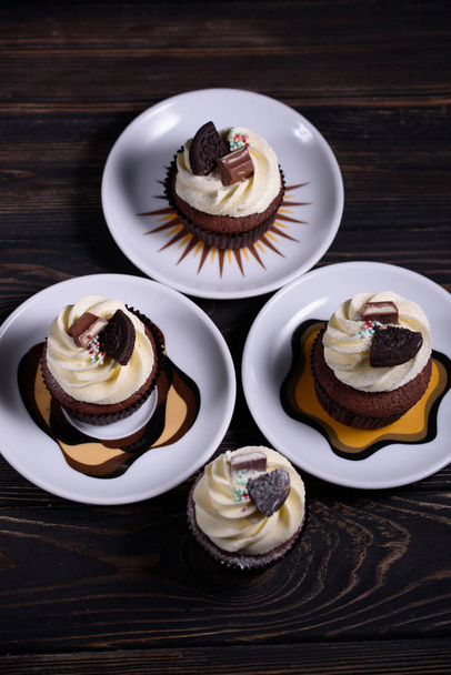 Chocolate, tasty and sweet cupcake with vanilla cream and condensed milk inside, - Фото, зображення