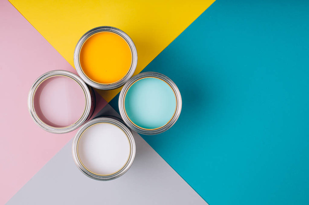 Four open cans of paint on bright symmetry background. - Фото, изображение