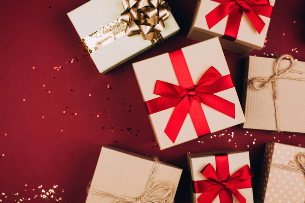 Muchos regalos de artesanía navideña sobre fondo rojo con brillo
. - Foto, Imagen