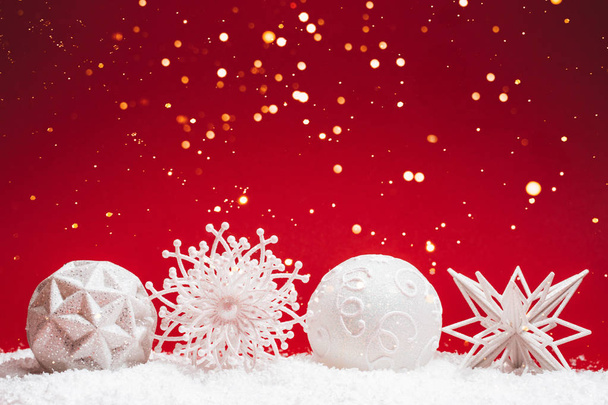 Cuatro juguetes decorativos de Navidad sobre fondo rojo con nieve
. - Foto, imagen