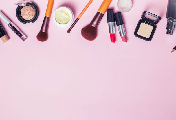 Borstels en make-up produts op de roze achtergrondkleur - Foto, afbeelding