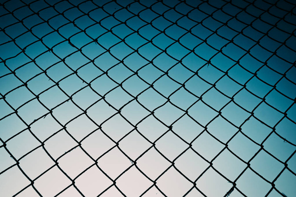Old metal mesh against the evening sky. Abstract background - Photo, Image