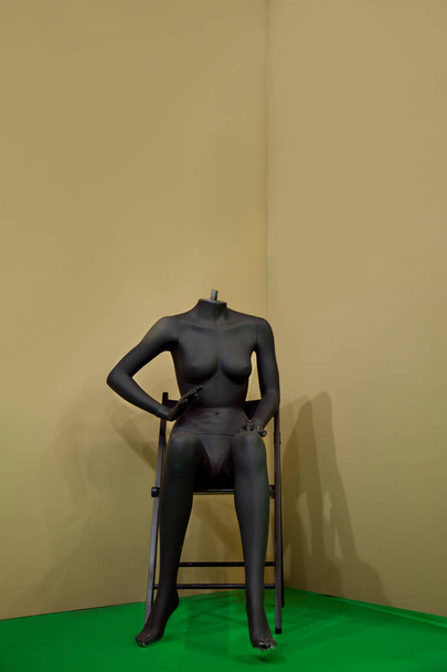黒い女性のマネキンが椅子に座り  - 写真・画像