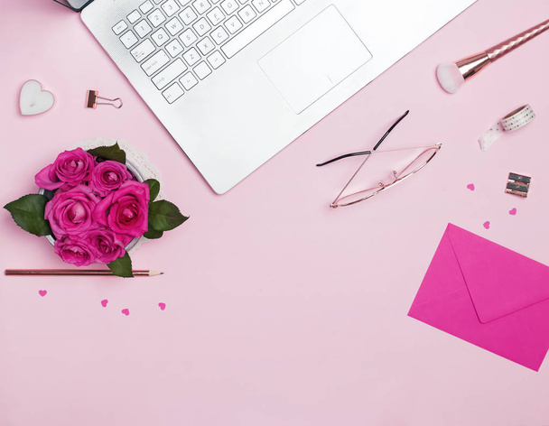 Laptop, roses, small papr hearts and other accessories on the pink background, top view - Foto, Bild