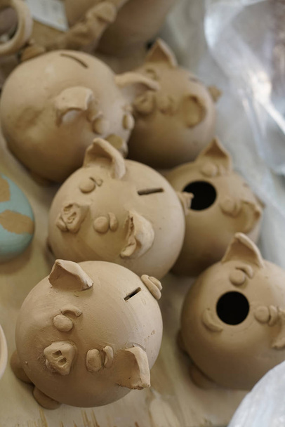 Przygotowanie mpney piggy Bank w postaci surowej gliny w pracowni ceramiki - Zdjęcie, obraz
