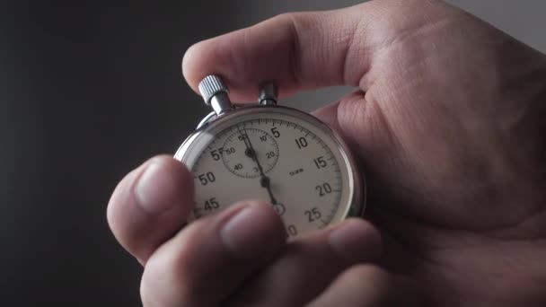 Primer plano de una persona que pone en marcha un cronómetro con fondo gris. 4K, 10 BIT, 4: 2: 2
. - Imágenes, Vídeo