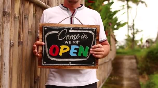Open teken boord in een man handen op de achtergrond van een tropische natuur. Shooted op Bali eiland, full Hd. - Video