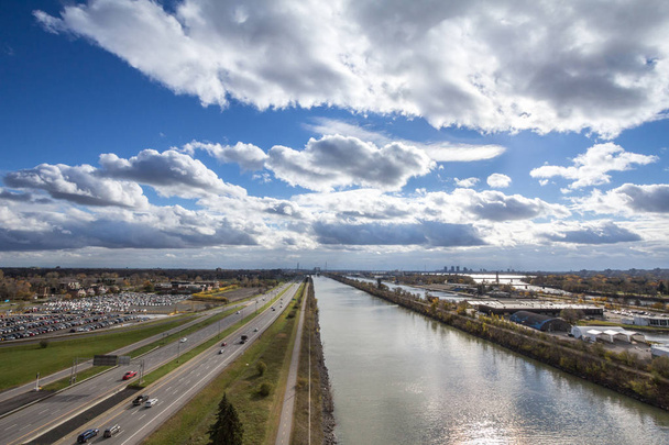 Paesaggio industriale nordamericano a Longueuil, nel sobborgo di Montreal, Quebec, Canada, con una grande autostrada, o autoroute, e il fiume San Lorenzo sullo sfondo
 - Foto, immagini
