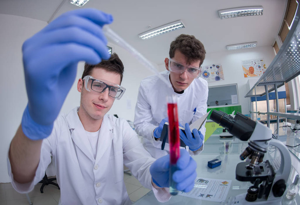 Groep van jonge medische studenten doen samen onderzoek in chemie laboratorium, teamwork door college student binnen - Foto, afbeelding