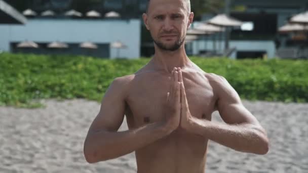 Portrait of sportsman practicing yoga and holding his hands together, steadicam shot. - Metraje, vídeo