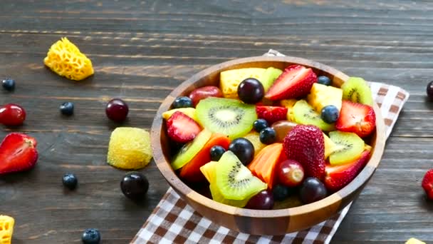 сортированные спелые фрукты и ягоды в деревянной чаше на деревенском столе
  - Кадры, видео