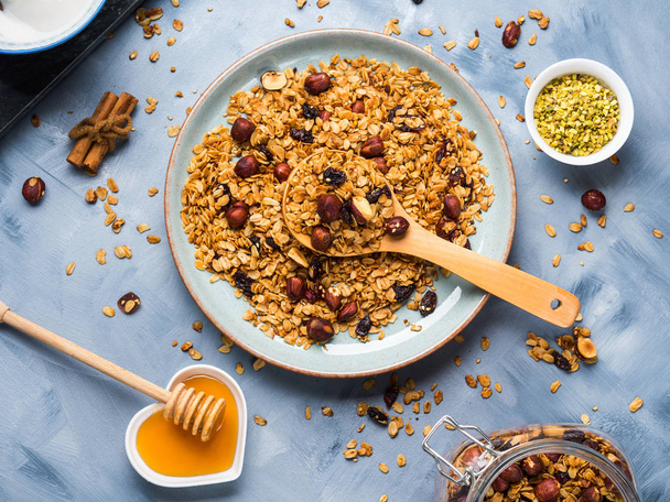 Homemade granola with honey, raisins, cherries, sesame and chestnuts on blue - Foto, immagini