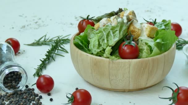 木製のボウルやテーブルの上の食材で美味しいシーザー サラダ - 映像、動画